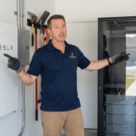 Installer comparing a wall mounted lithium battery vs rack battery in a modern residential garage